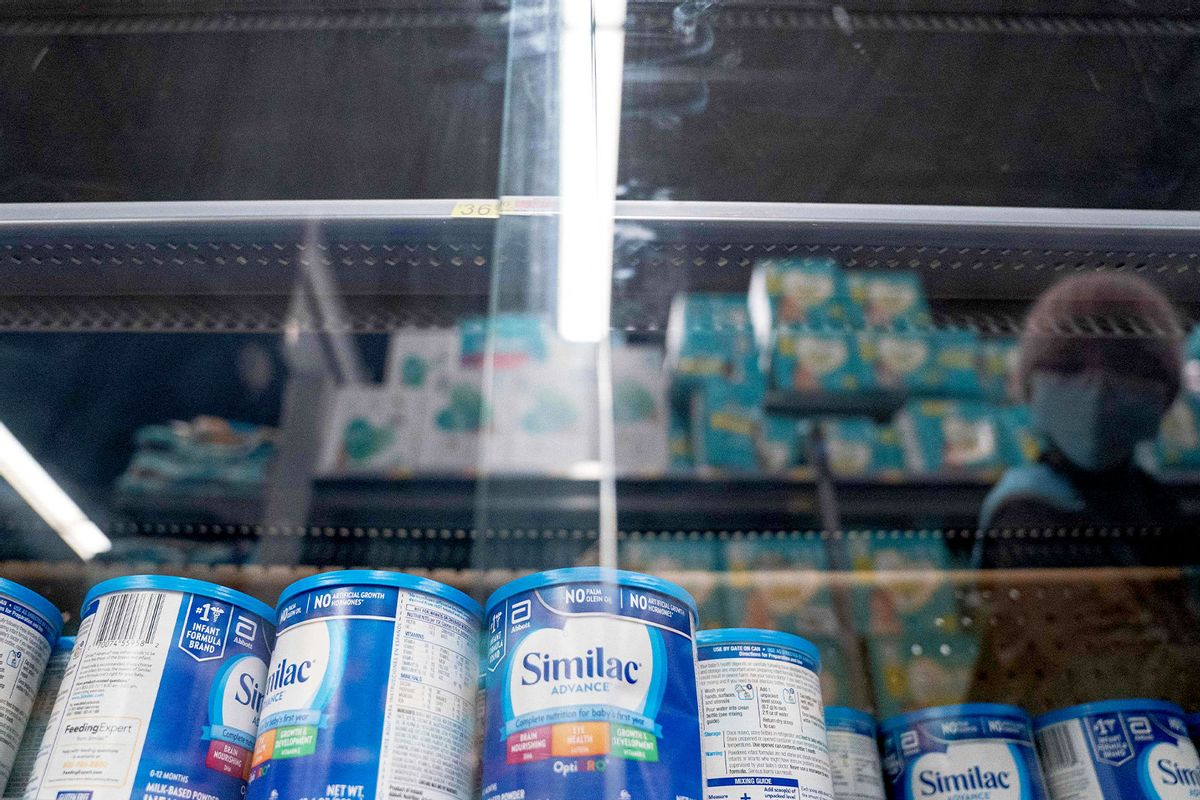 A shopper is reflected in a glass case while looking at baby formula at a grocery store in Washington, DC, on May 11, 2022. The United States is in the grip of a severe shortage of baby formula. (STEFANI REYNOLDS/AFP via Getty Images)