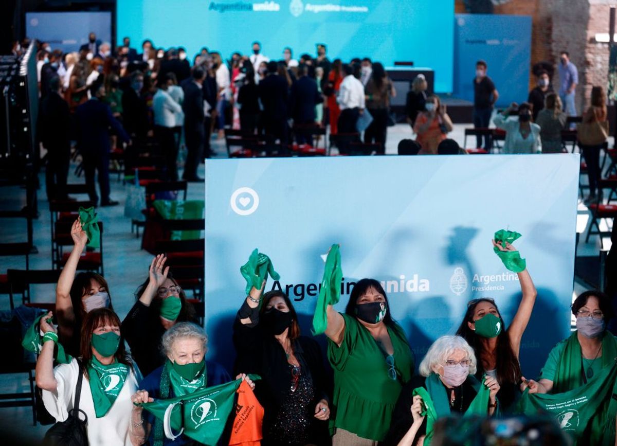 Women celebrate after Argentina's President Alberto Fernandez (background) promulgated the abortion law known as Voluntary Interruption of Pregnancy Law in Buenos Aires on Jan. 14, 2021. (EMILIANO LASALVIA/AFP via Getty Images)