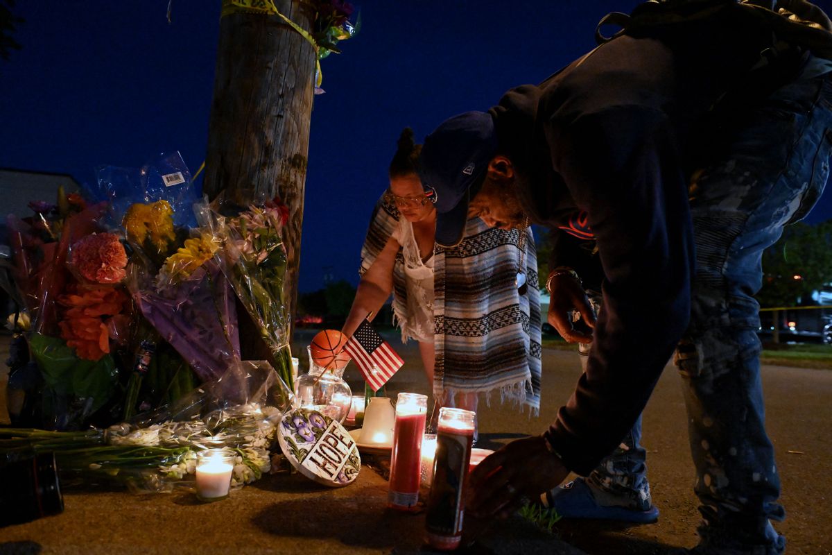 People light candles at a makeshift memorial near a Tops Grocery store in Buffalo, New York, on May 15, the day after a gunman shot dead 10 people. (Usman Khan/AFP via Getty Images)