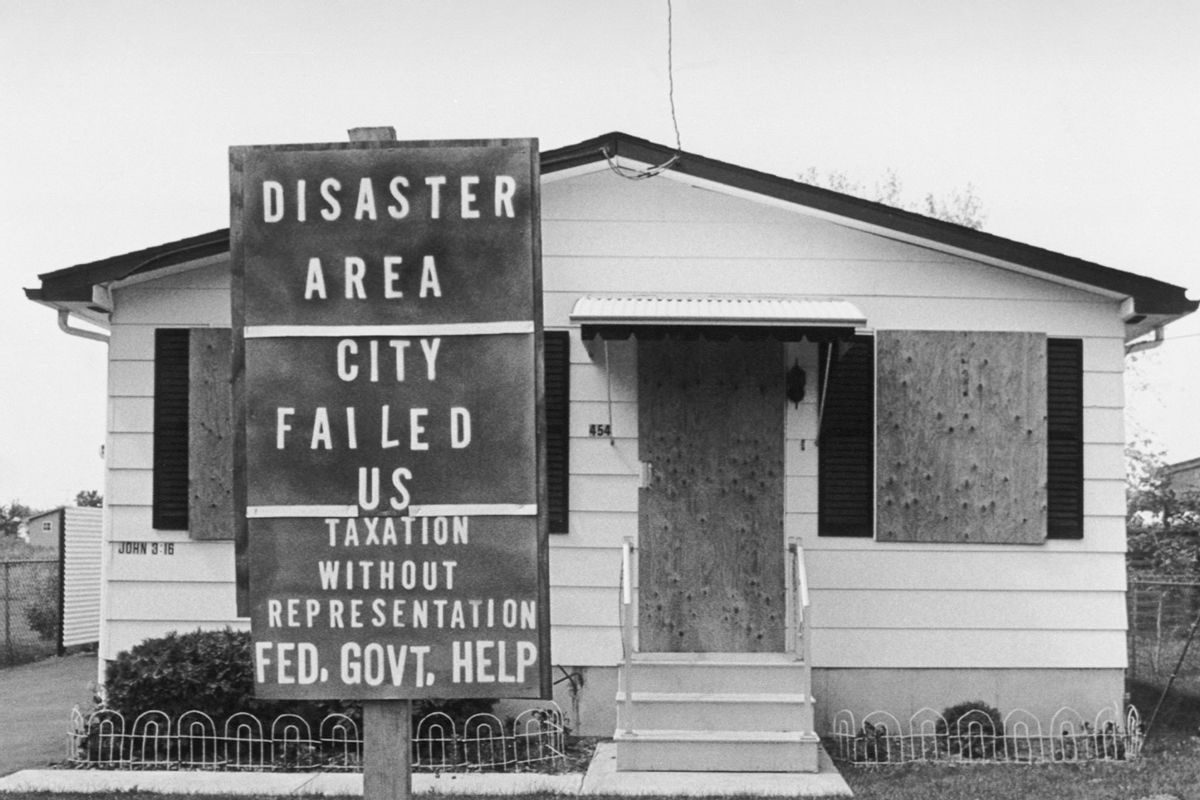 A protest sign stands in front of an evacuated and boarded up house in the Love Canal neighborhood in Niagara Falls. The area was abandoned after it was learned that tons of toxic waste were dumped in the canal beside the houses. (Getty Images/Bettmann Contributor)