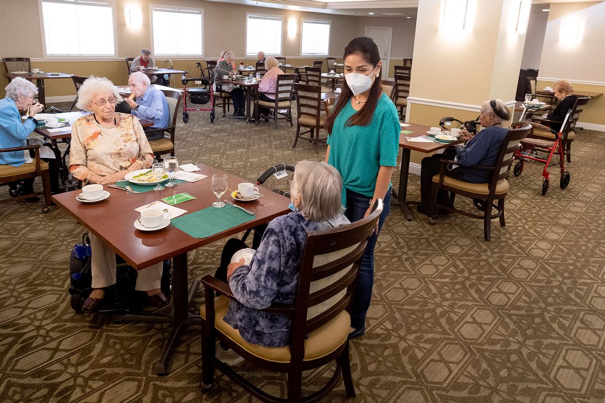 Residents talk with a caregiver in the dining room at Emerald Court in Anaheim, CA on Monday, March 8, 2021. (Paul Bersebach/MediaNews Group/Orange County Register via Getty Images)