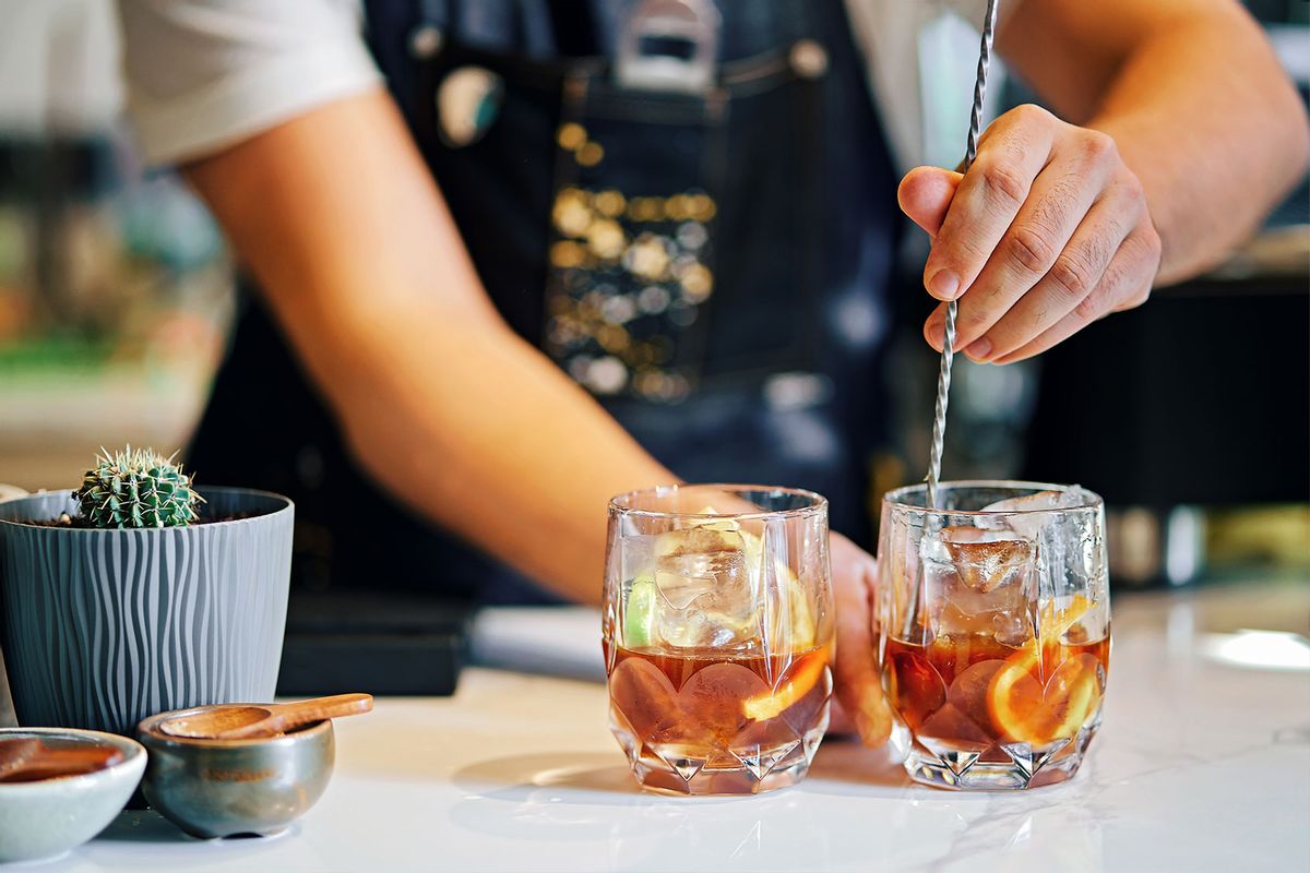 Bartender mixing cocktails in bar (Getty Images/YorVen)