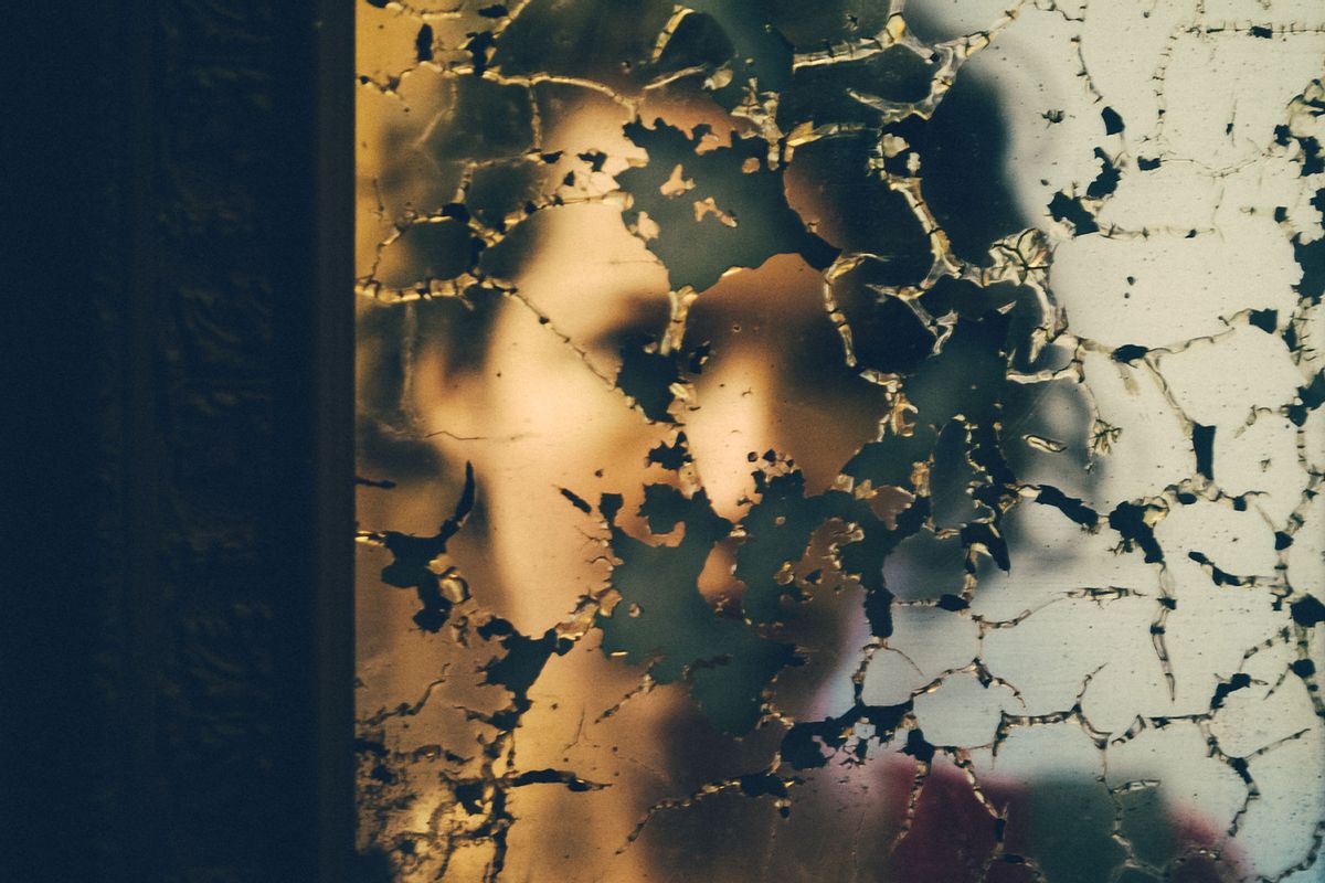 Young woman blurry reflection on the damaged mirror (Getty images/Rafael Elias)