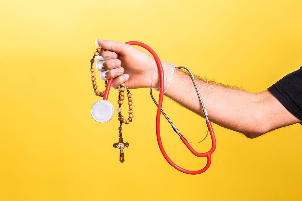 Doctor holding a rosary with his stethoscope (Getty Images/Joaquin Corbalan)