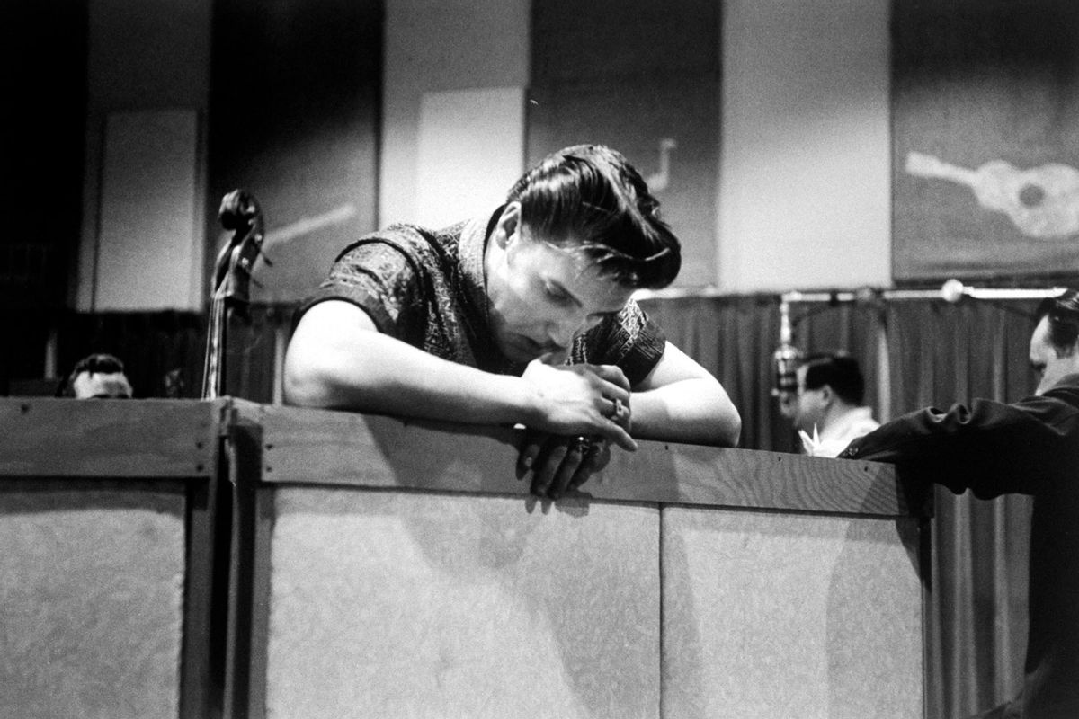 Singer Elvis Presley, looking tired and somewhat dejected, leaning over railing in recording studio during break from cutting new record. (Don Cravens/Getty Images)