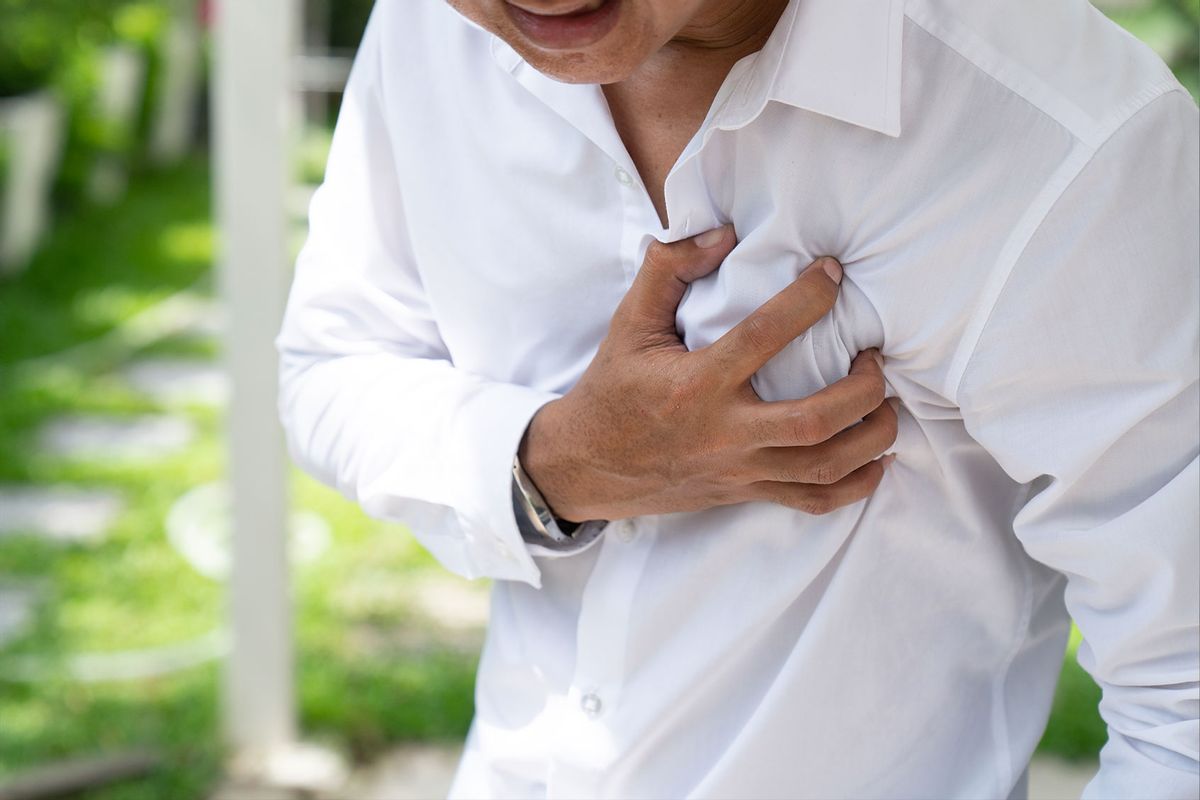 Man clutching his chest from acute pain (Getty Images/Witthaya Prasongsin)