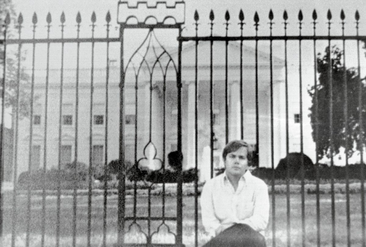 John Hinckley Jr., as he sits on fence wall in front of the White House (Bettmann / Getty Images )