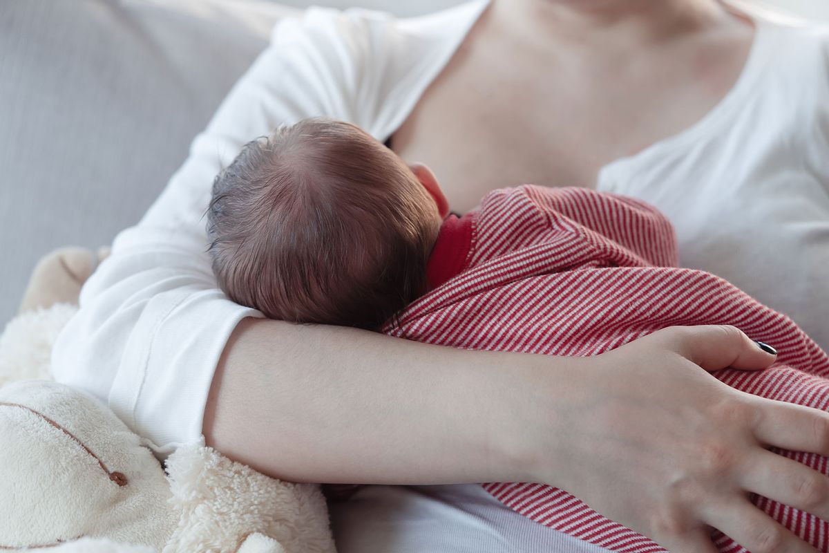 Mom breastfeeding a baby (Getty Images/istetiana)