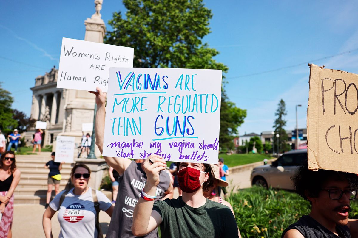 A protester holds a placard saying, "Vaginas are more regulated than guns, maybe my vagina should start shooting bullets," during a Women's March to demand safe and legal access to abortion. (Jeremy Hogan/SOPA Images/LightRocket via Getty Images)
