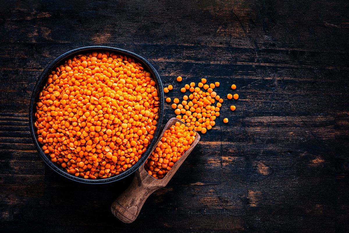 Red lentils in a black bowl shot from above on dark wooden table (Getty Images/fcafotodigital)