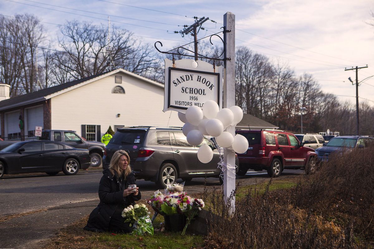 Local residents place flowers near the Sandy Hook Elementary School December 15, 2012 in Sandy Hook, Connecticut for the 28 children and faculty shot and killed one day earlier on December 14, 2012. (Robert Nickelsberg/Getty Images)