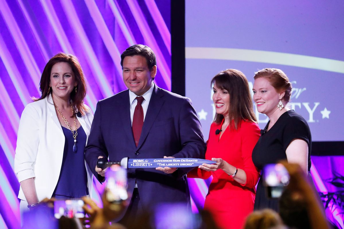 Moms for Liberty founders Tiffany Justice (L) and Tina Descovich present the Liberty Sword to Governor Ron DeSantis before he speaks during the inaugural Moms For Liberty Summit at the Tampa Marriott Water Street on July 15, 2022 in Tampa, Florida. (Octavio Jones/Getty Images)