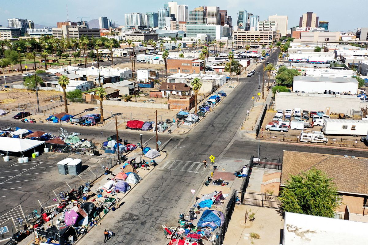An aerial view shows people walking past a homeless encampment in the afternoon heat on July 21, 2022 in Phoenix, Arizona. The National Weather Service issued an excessive heat warning for eight counties in Arizona including Maricopa County today. (Mario Tama/Getty Images)