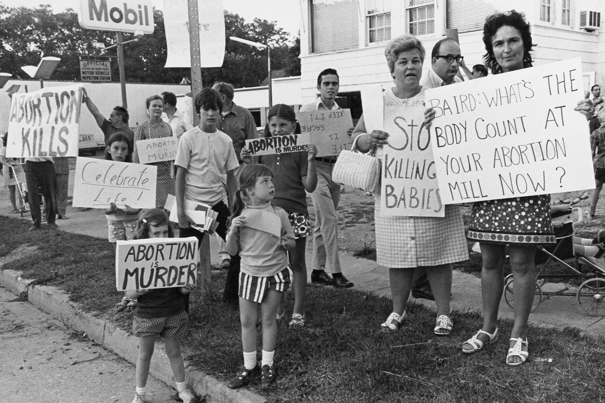 An anti-abortion picket, with protestors holding placards reading 'Abortion Kills', 'Celebrate Life', 'Abortion is Murder,' 'Stop Killing Babies' and 'Baird: What's the Body Count at Your Abortion Mill Now?', with a sign for a Mobil petrol station in the background, picket a birth control lecture by reproductive rights advocate Bill Baird, United States, 13th August 1971. (Peter L Gould/FPG/Archive Photos/Hulton Archive/Getty Images)