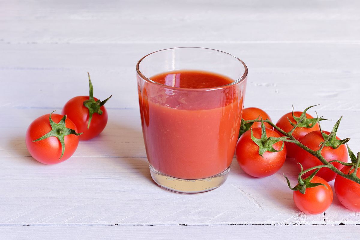Tomato juice and fresh tomatoes on a white wooden table (Getty Images/Nodar Chernishev)