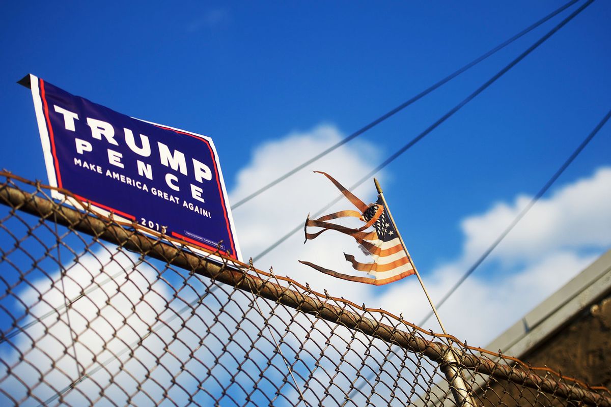 A tattered flag waves beside a Donald Trump campaign sign in the background of a residence on October 19, 2016 (Mark Makela/Getty Images)