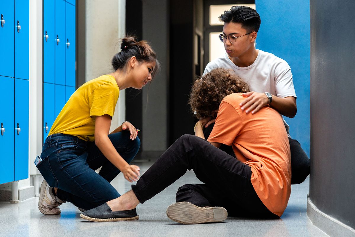 Two students comfort a classmate in the corridor (Getty Images/Daniel de la Hoz)
