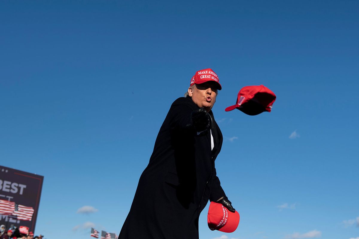 Donald Trump throws hats to supporters during a Make America Great Again rally on November 2, 2020, in Avoca, Pennsylvania. (BRENDAN SMIALOWSKI/AFP via Getty Images)