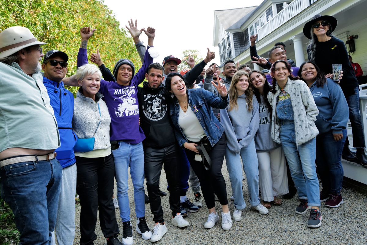 Venezuelan migrants and volunteers celebrate together on Sept. 16 outside St. Andrew's Parish House on Martha's Vineyard. (Carlin Stiehl for the Boston Globe via Getty Images)