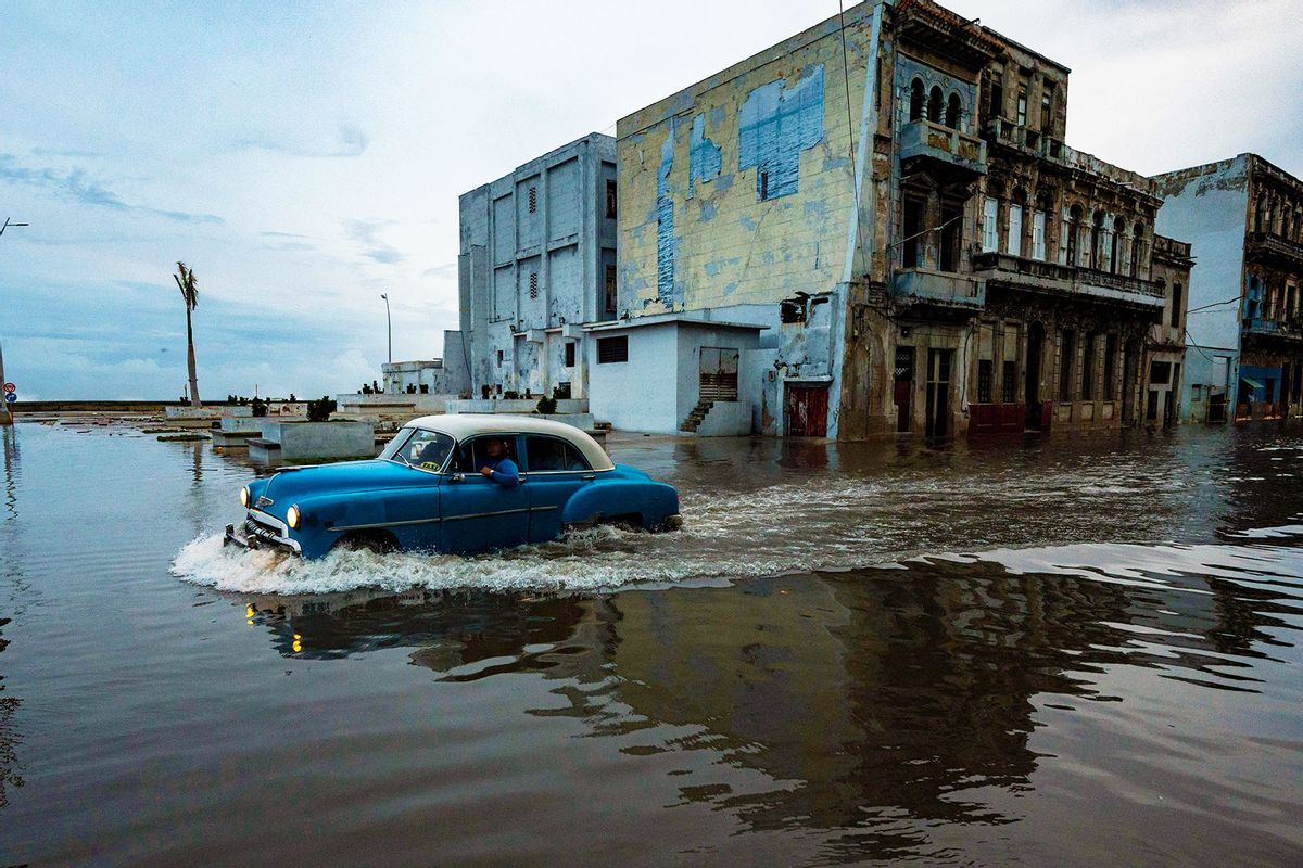 An old American car passes through a flooded street in Havana, on September 28, 2022, after the passage of hurricane Ian. (YAMIL LAGE/AFP via Getty Images)