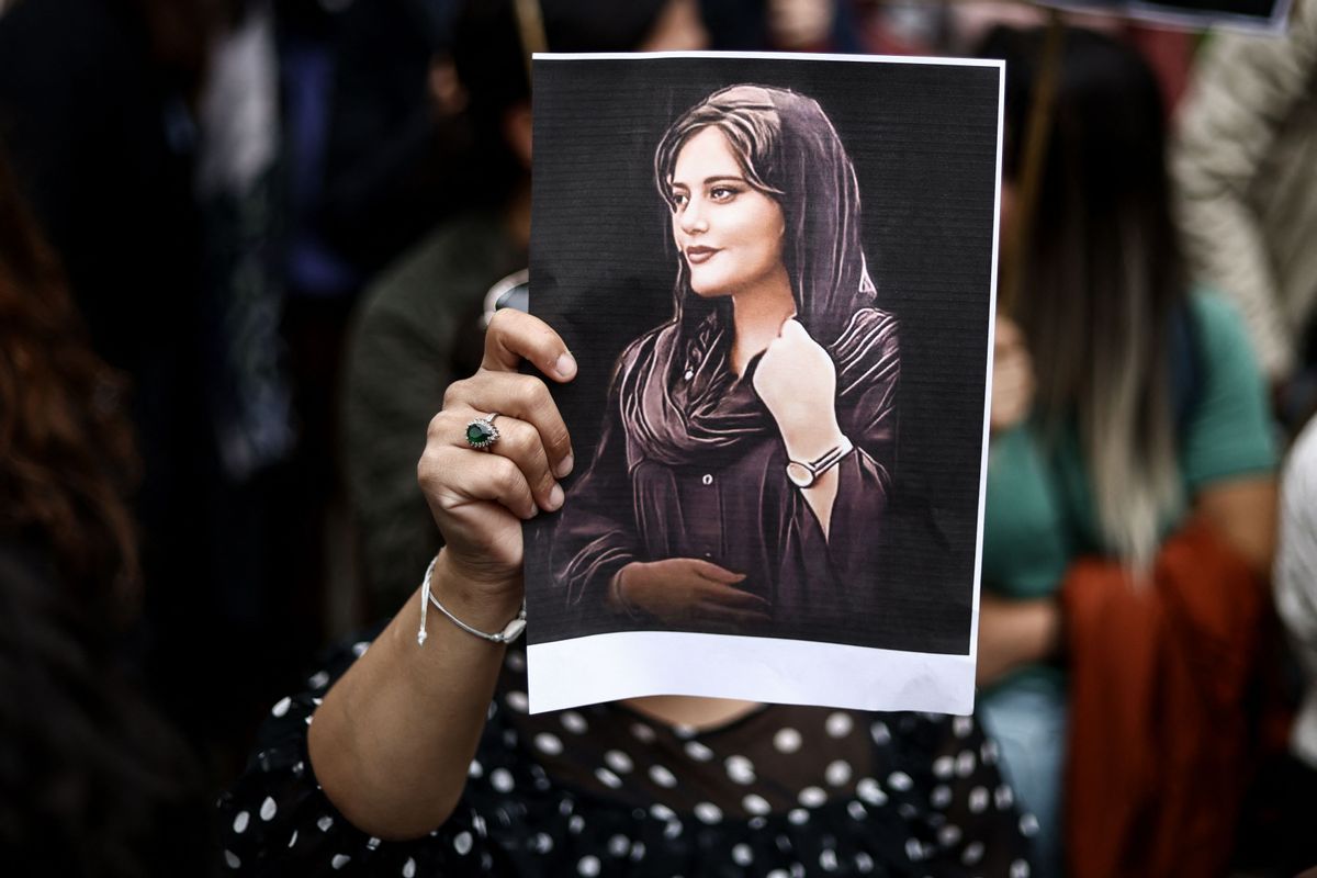 A protester holds a portrait of Mahsa Amini during a demonstration in her support in front of the Iranian embassy in Brussels on September 23, 2022, following the death of an Iranian woman after her arrest by the country's morality police in Tehran.
 (KENZO TRIBOUILLARD/AFP via Getty Images)