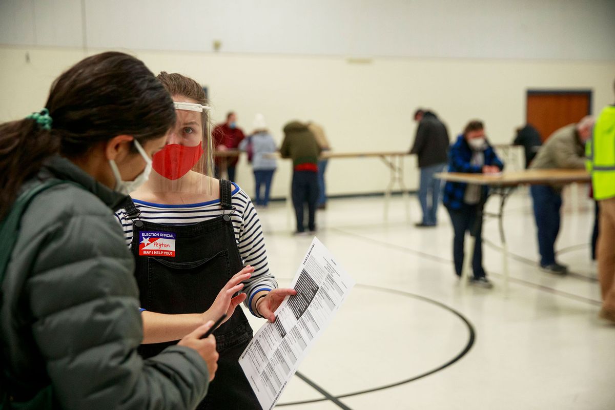 A poll worker speaks to a voter at St. John the Apostle Catholic Church. (Jeremy Hogan/SOPA Images/LightRocket via Getty Images)