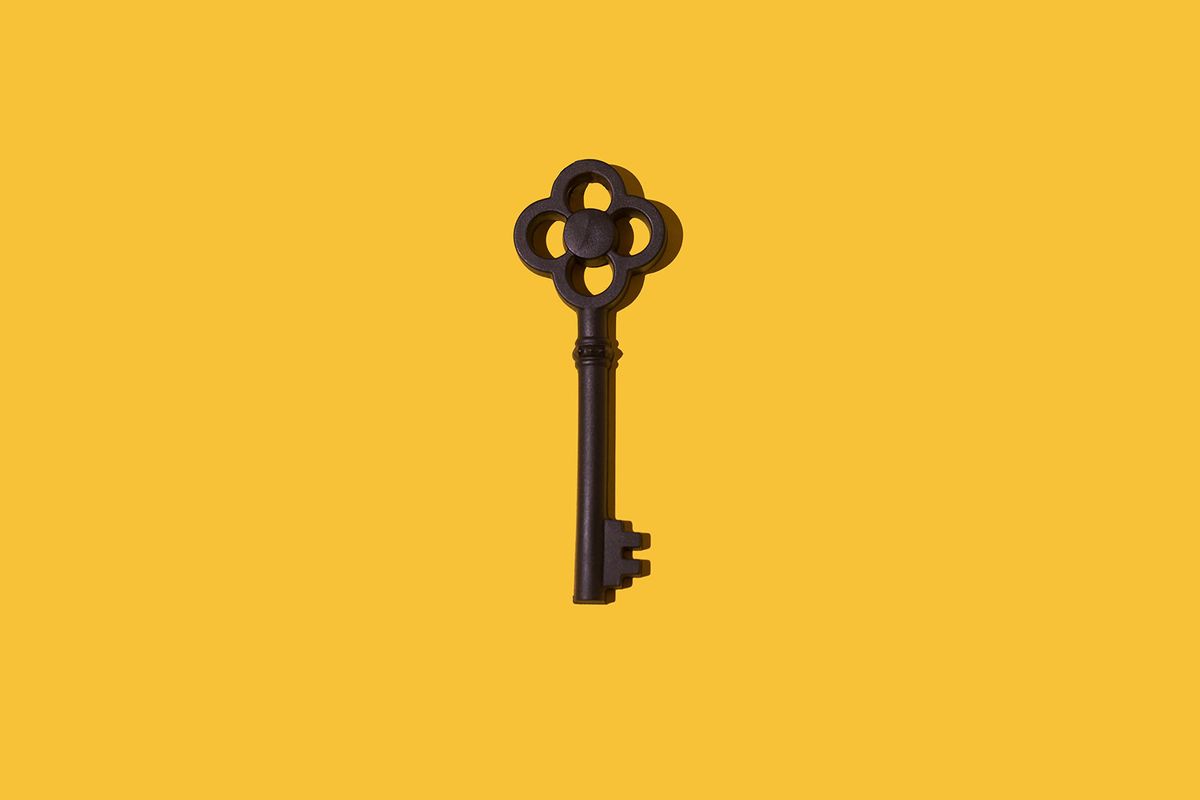 Black color vintage key with hard shadow on yellow background (Getty Images/DBenitostock)