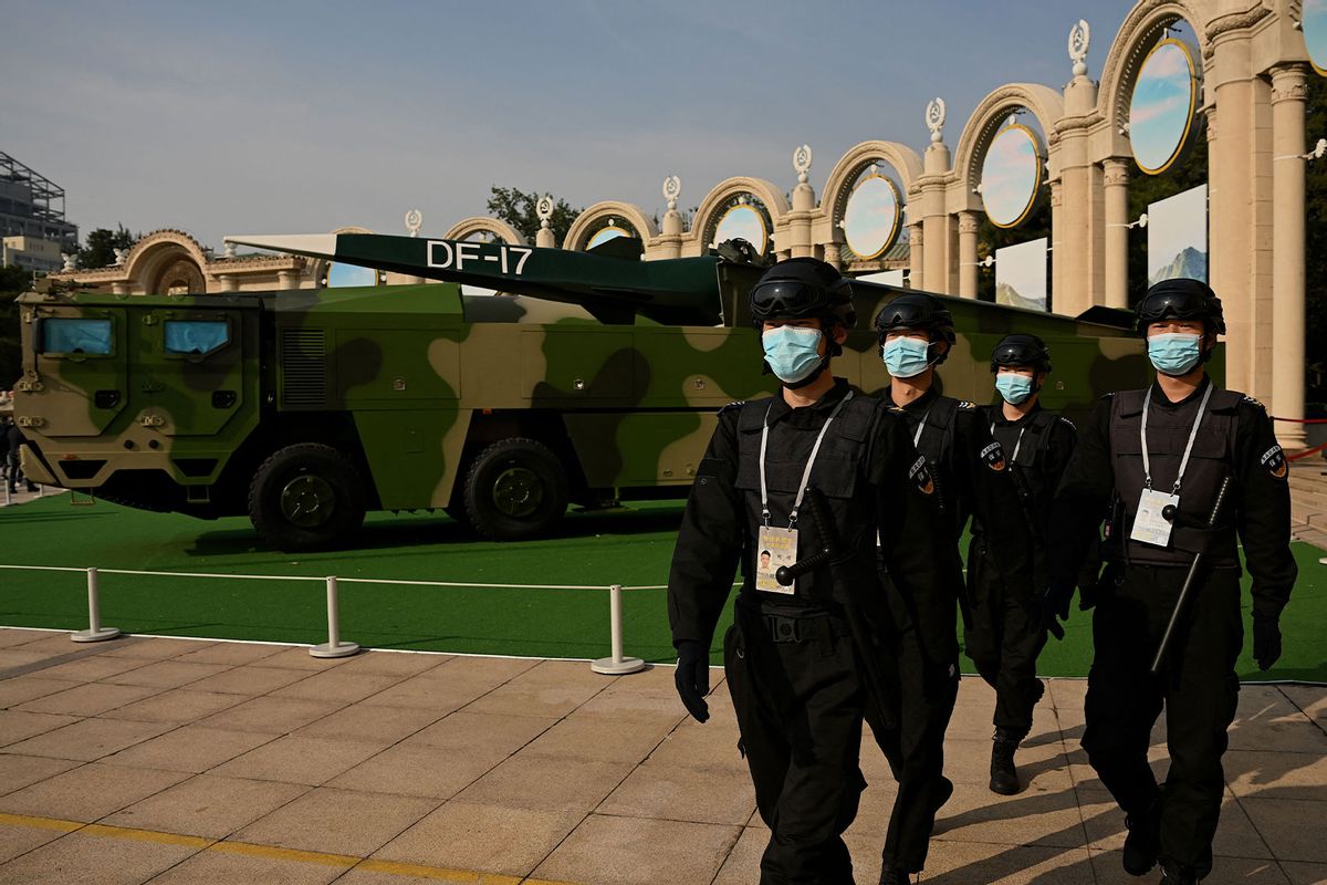 Security personnel march in front of a Dongfeng-17 medium-range ballistic missile and its mobile launcher on display at the Beijing Exhibition Center (NOEL CELIS/AFP via Getty Images)