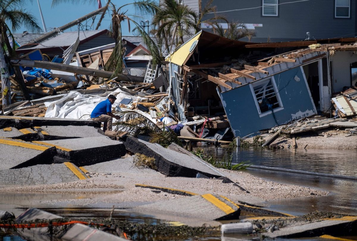 A man sits on a broken section of the Pine Island Road in the aftermath of Hurricane Ian in Matlacha, Florida on October 1, 2022.  (RICARDO ARDUENGO/AFP via Getty Images)