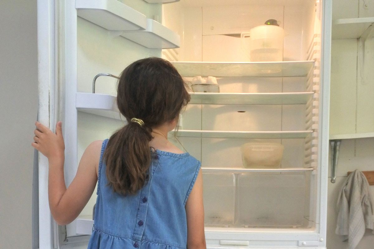 Hungry girl looks for food in empty fridge at home (Getty Images/Rafael Ben-Ari)