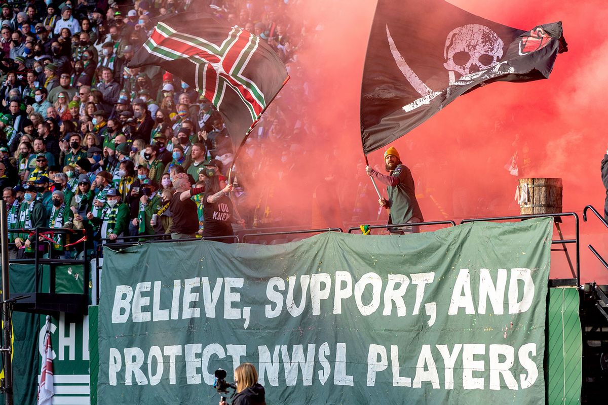 Portland Timbers fans set off red smoke in support of the NWSL womens soccer palyers as their ongoing protest over the sexual harrassment scandal by former Portland Thorns coach, Paul Riley, at during the Portland Timbers game Minnesota United first round MLS Cup Playoffs match on November 21, 2021, at Providence Park, Portland, OR (Diego Diaz/Icon Sportswire via Getty Images)