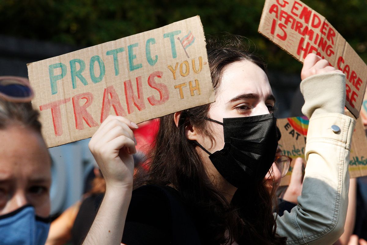 A trans rights protester stands outside of Boston Childrens Hospital to face off with anti-trans protesters across the street. (Carlin Stiehl for The Boston Globe via Getty Images)