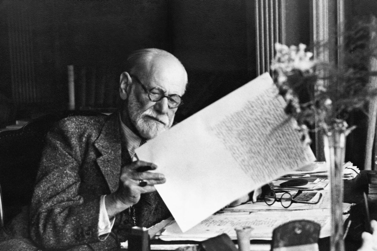 Sigmund Freud, 1856-1939, Austrian psychiatrist, in the office of his Vienna home looking at a manuscript (Getty Images/Bettmann Contributor)