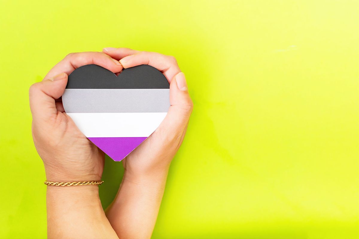 Woman hands hold heart in the colors of asexual flag (Getty Images/Marcela Ruth Romero)