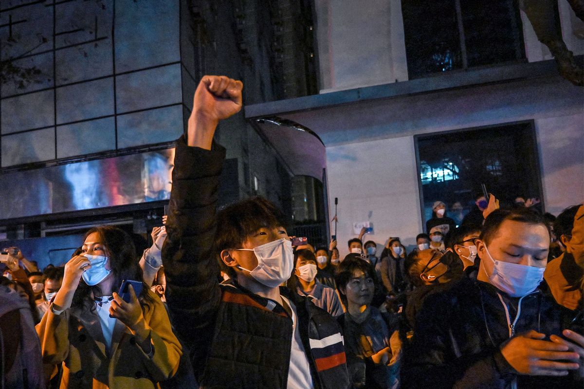 People sing slogans while gathering on a street in Shanghai on November 27, 2022, where protests against China's zero-Covid policy took place the night before following a deadly fire in Urumqi, the capital of the Xinjiang region. (HECTOR RETAMAL/AFP via Getty Images)