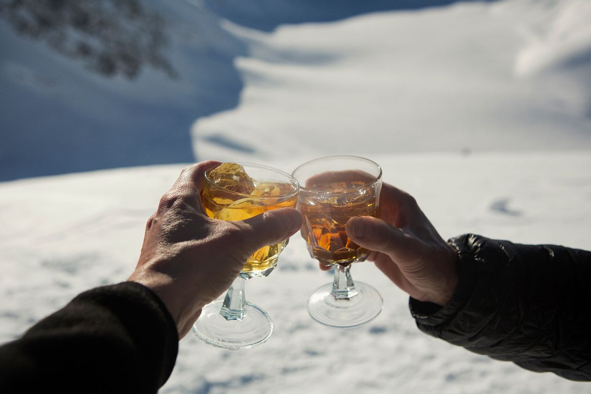 Friends toasting cocktails in the snow (Getty Images/Jocelyn Michel)