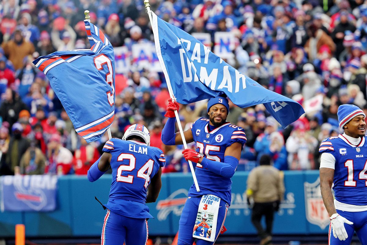 Kaiir Elam #24 and Taiwan Jones #25 of the Buffalo Bills wave flags in support of Buffalo Bills safety Damar Hamlin at Highmark Stadium on January 08, 2023 in Orchard Park, New York.  (Timothy T Ludwig/Getty Images)