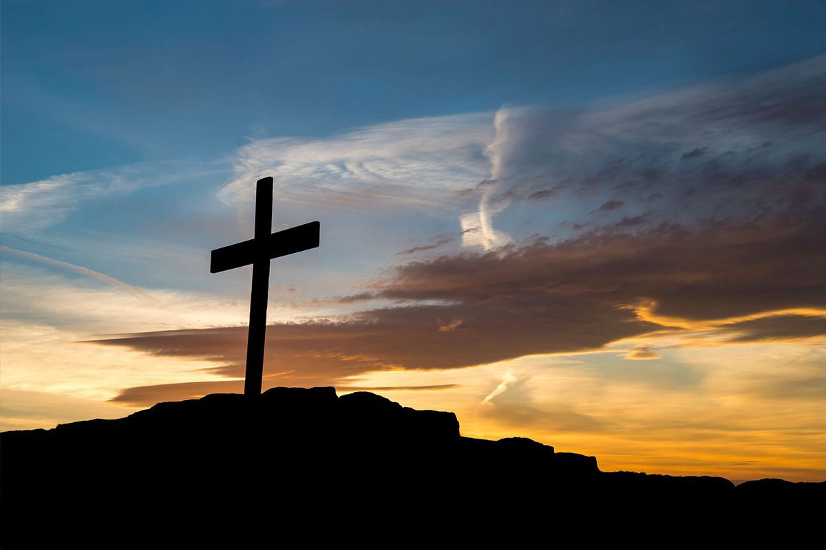 Wooden cross on a hilltop at sunset (Getty Images/Photos by R A Kearton)