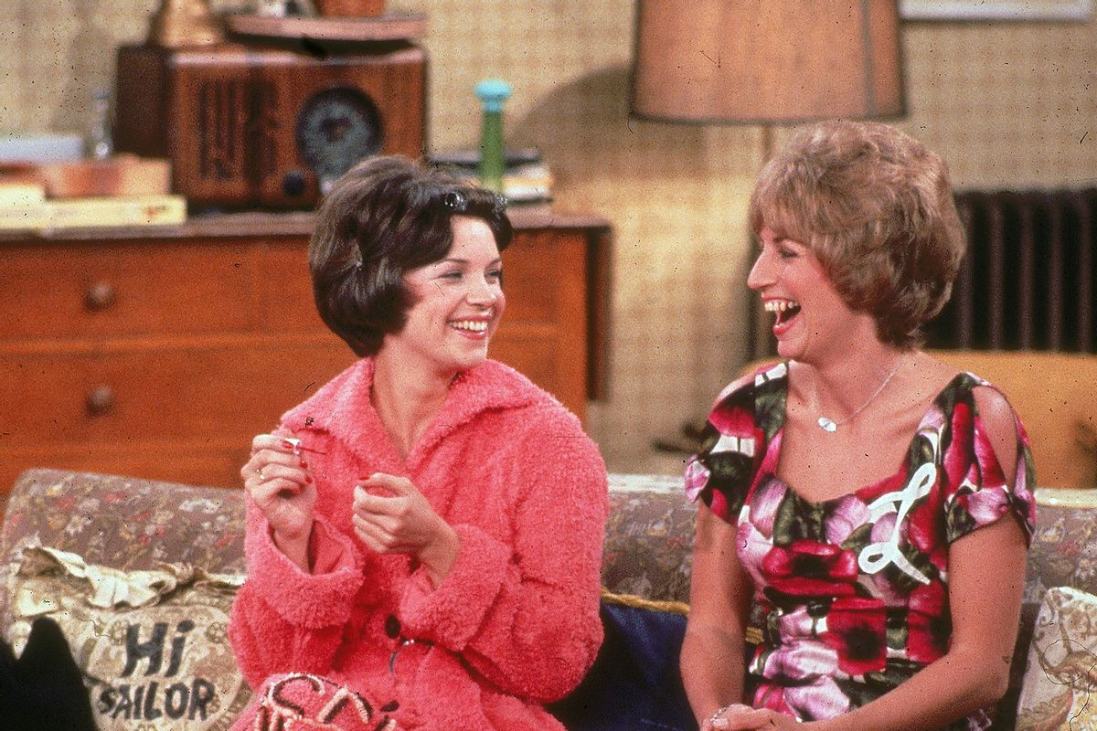 American actors Cindy Williams (left) and Penny Marshall sit on their sofa laughing in a still from the television program, 'Laverne & Shirley.' (Paramount Television/Fotos International/Getty Images)