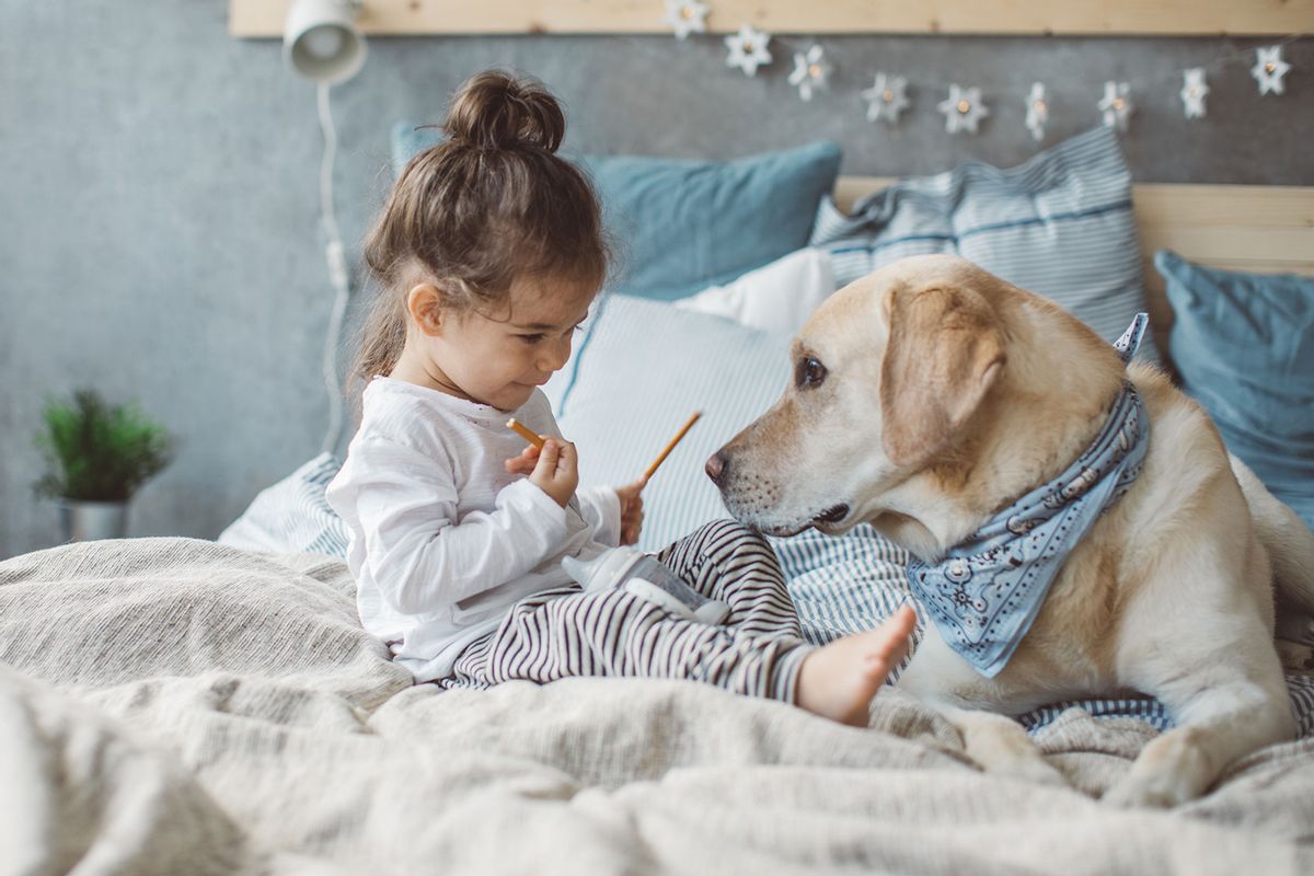 Dog and boy sharing a pretzel (Getty Images/svetikd)