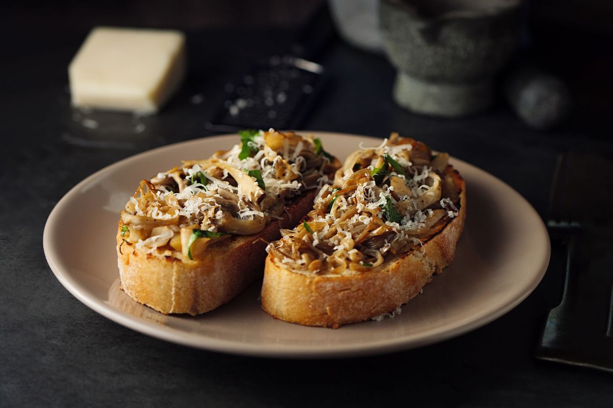 Toasted sourdough bread with sauteed mushroom and hard goat cheese (Getty Images/haoliang)