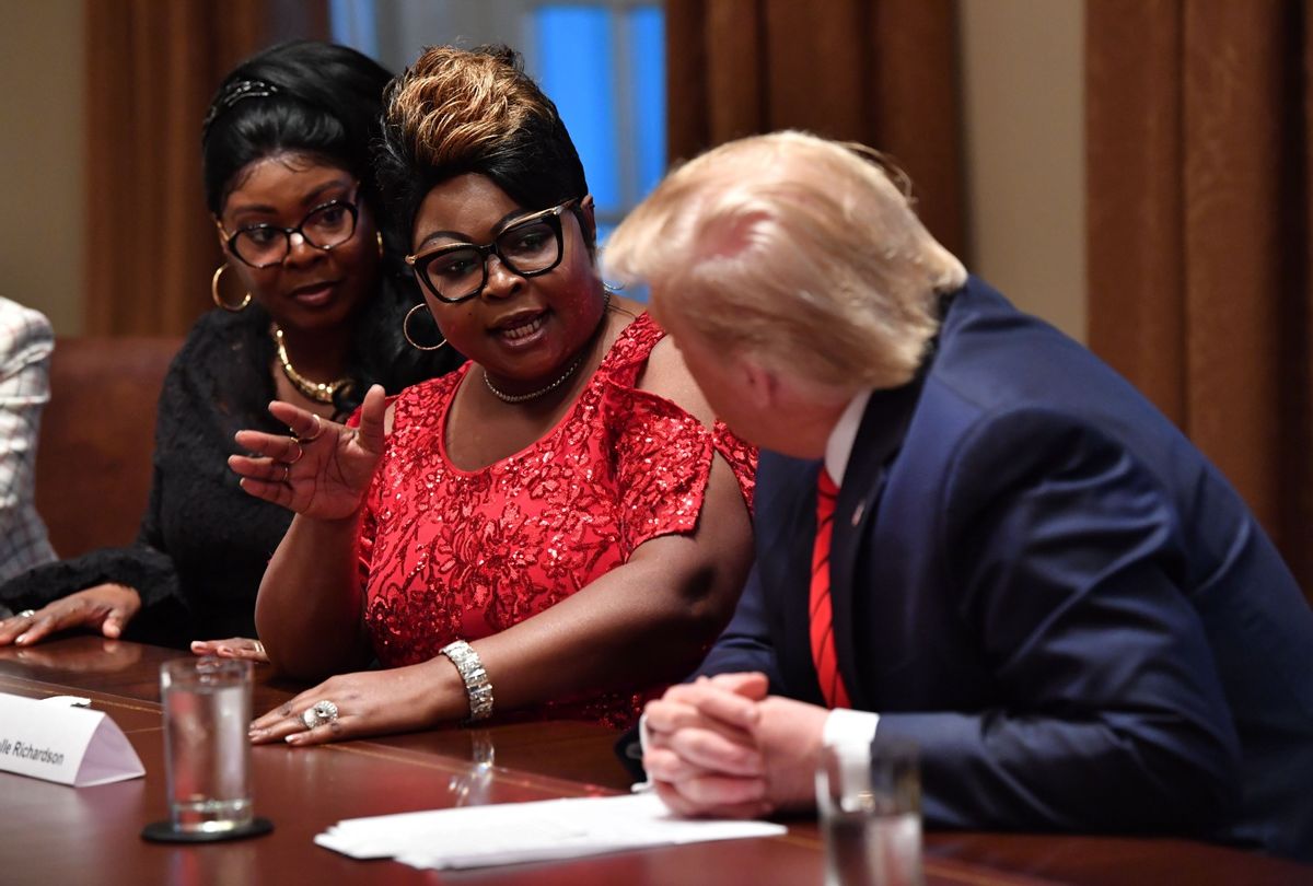 Former President Donald Trump listens as social media personalities Lynnette Hardaway (L) and Rochelle Richardson (2-L), otherwise known as Diamond and Silk, speak during a meeting with African-American leaders in the Cabinet Room of the White House in Washington, DC, on February 27, 2020. (NICHOLAS KAMM/AFP via Getty Images)