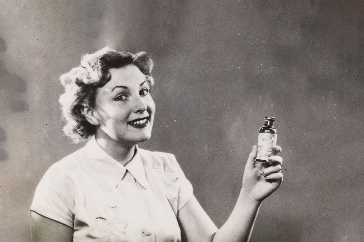 Woman holds up bottle of medicine for advertisement photoshoot, 1920-60. (Science & Society Picture Library/SSPL/Getty Images)