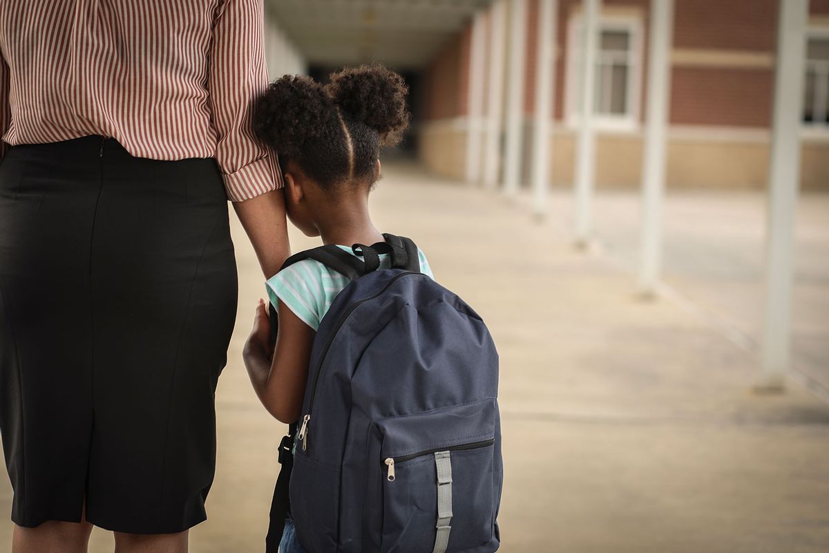 Little girl with mom on first day of school. (Getty Images/fstop123)