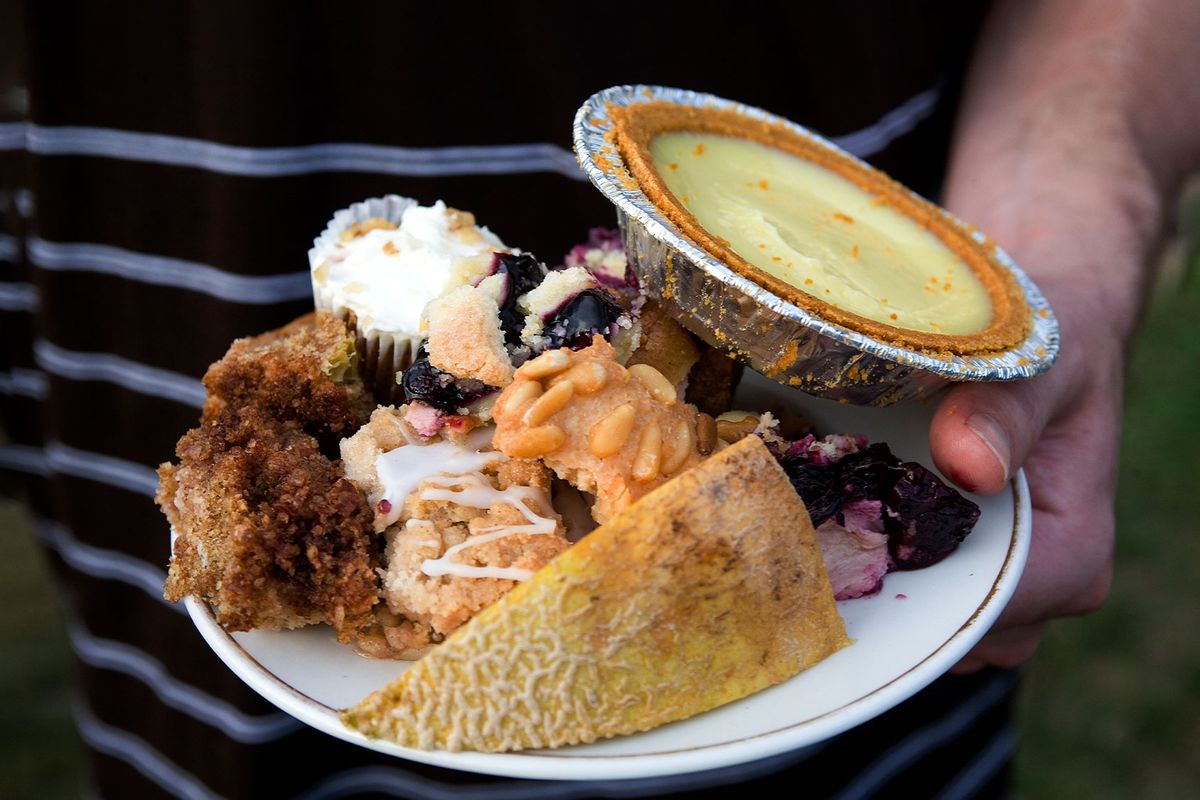 A man carries a plate of high-calorie, unhealthy, sugary, fattening desserts: cakes, key lime pie, and a healthy piece of cantaloupe. (ANDREW HOLBROOKE/Corbis via Getty Images)