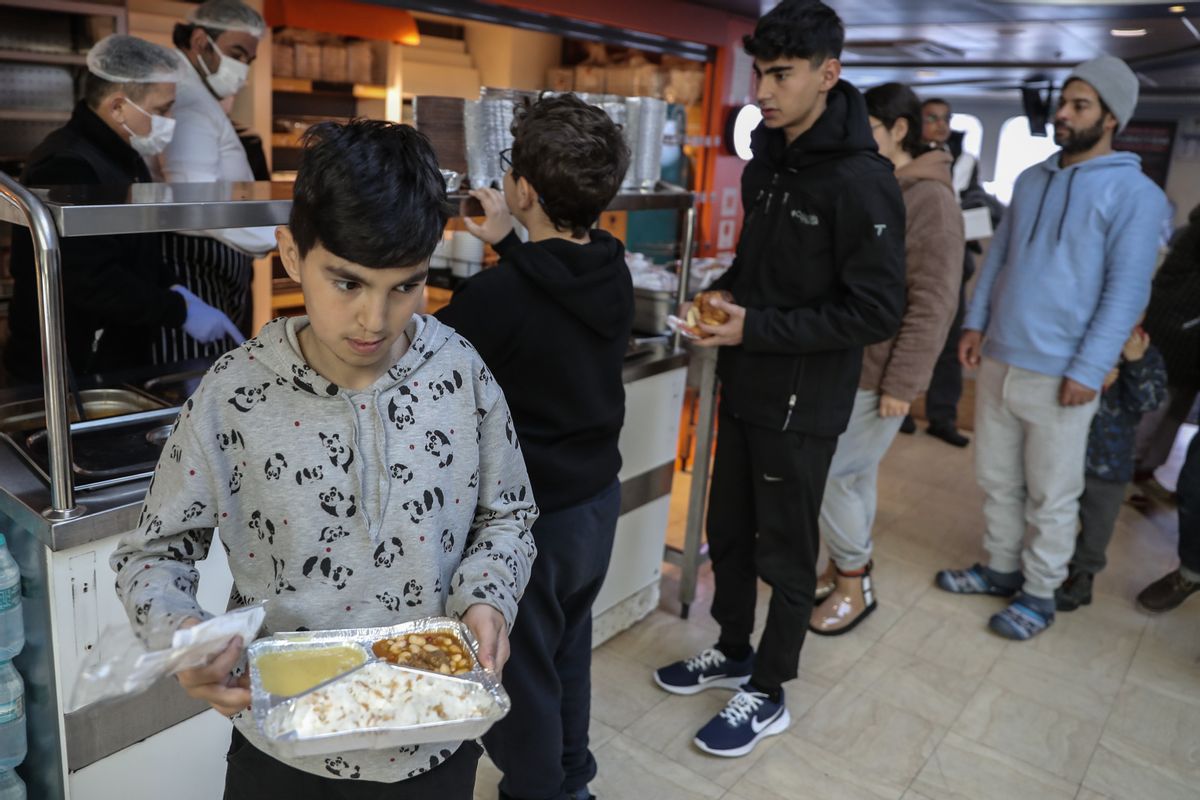 Earthquakes victims onboard an Istanbul Municipality ferry being used as a temporary shelter receive hot meal on February 15, 2023 in Iskenderun, Turkey. (Burak Kara/Getty Images)