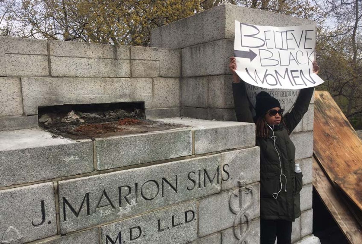A woman demonstrates next to the empty pedestal after workers removed the statue of Dr. James Marion Sims on April 17, 2018, in New York. (THOMAS URBAIN/AFP via Getty Images)