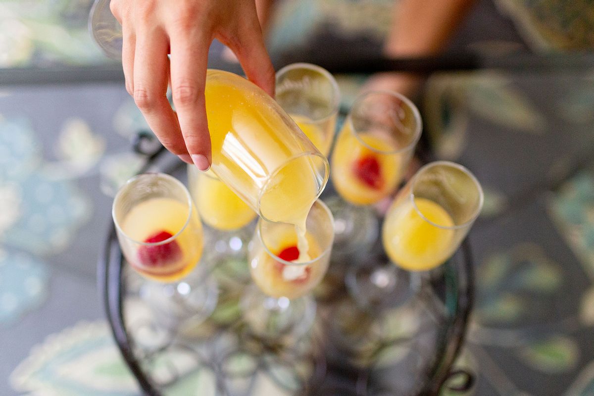 Orange juice and champagne mixed in a glass to make a mimosa with strawberries (Getty Images/Kevin Trimmer)