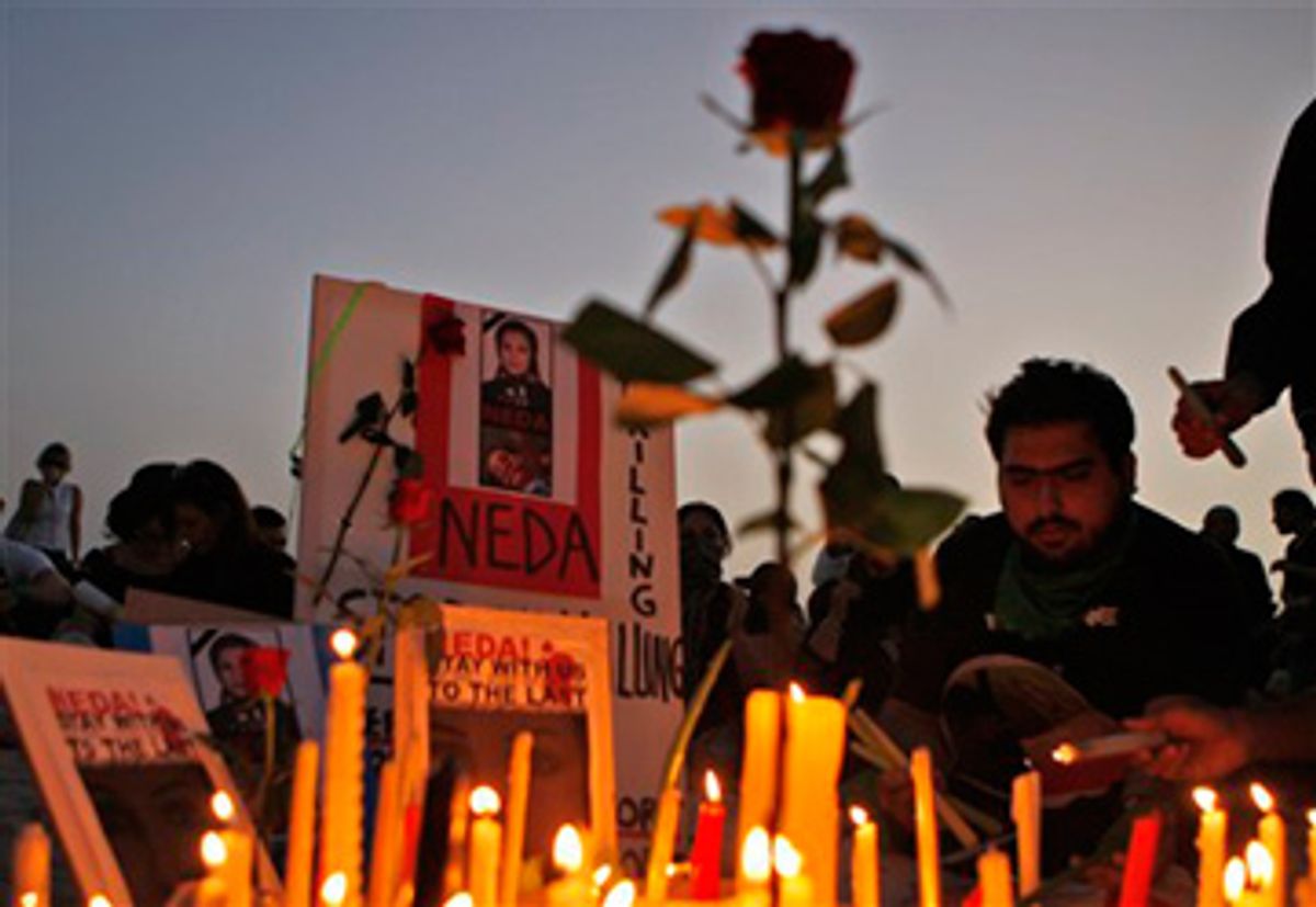 Iranians light candles in front the image of Neda Agha Soltani, who was reportedly killed when hit by a bullet during a protest in Tehran two days ago, in Dubai, United Arab Emirates, Monday, June 22, 2009. Hundreds of supporters of reformist presidential candidate Mir Hossein Mousavi attended a silent rally today.