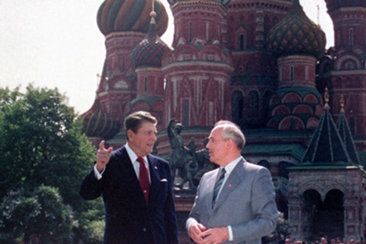 Top: U.S. President Ronald Reagan, left, and Soviet leader Mikhail Gorbachev stand alone during their impromptu walk in Red Square in Moscow, USSR, Tuesday, May 31, 1988. In the background is St. Basil's Cathedral. Bottom: East German border guards look through a hole in the Berlin wall after demonstrators pulled down one segment of the wall at Brandenburg gate in this November 11, 1989 picture.